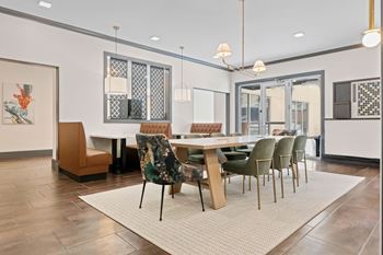 A dining room with a table surrounded by chairs at Aster Apartments, Beachwood